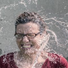 表情包制作主编林知远的工作照：戴着细框眼镜的中年男性坐在堆满打印稿的办公桌前，正用红笔在概念分类表上做标记，背景是贴满便签的白板，氛围严谨